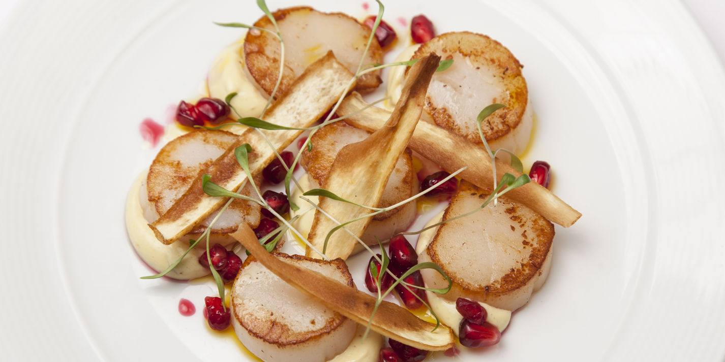 Scallops with curried parsnip purée, parsnip crisps and pomegranate