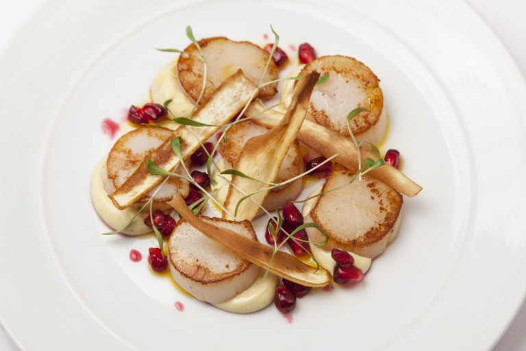 Scallops with curried parsnip purée, parsnip crisps and pomegranate