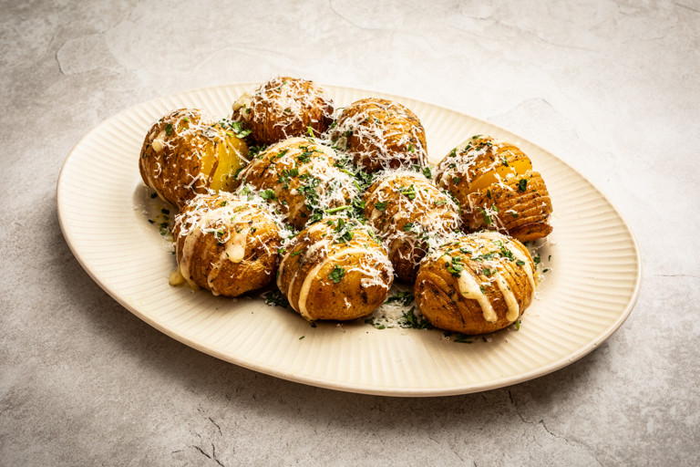 Barbecued hasselback potatoes with garlic butter and Gruyère