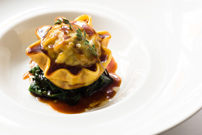 Braised oxtail raviolo with celeriac, sautéed spinach and oxtail jus