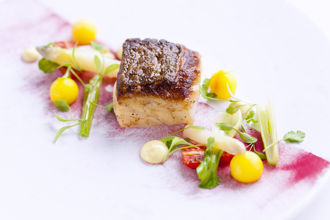 Roast fillet of cod with saffron potatoes and tomatoes