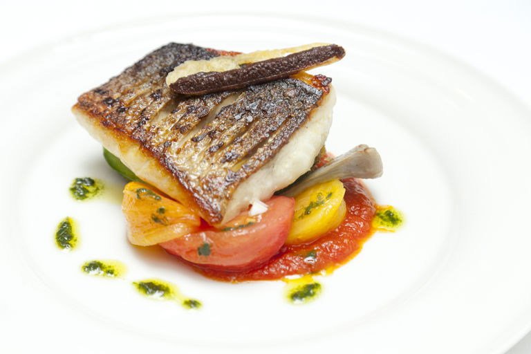 Griddled sea bass with stuffed courgettes, tomatoes, olives and basil