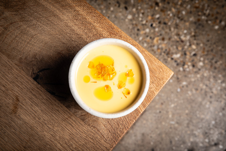 Chilled melon and cucumber soup with raw scallop and marigold