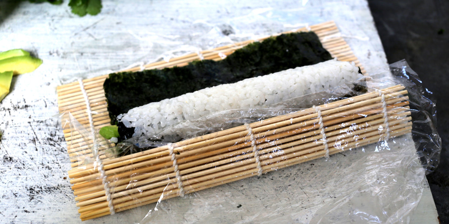 Sushi ingredients, nori seaweed on makisu bamboo mat for rolling, fresh raw  salmon, raw sushi rice, soy sauce and chopsticks on the side Stock Photo -  Alamy