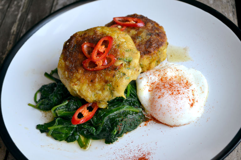 Curried fish cakes with spinach and poached egg