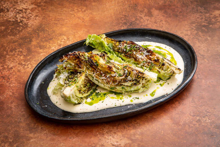 Charred hispi cabbage with Parmesan cream and herb oil