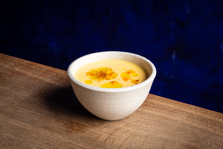 Chilled melon and cucumber soup with raw scallop and marigold
