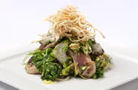 Honey marinated duck breast with sautéed greens and crispy noodles