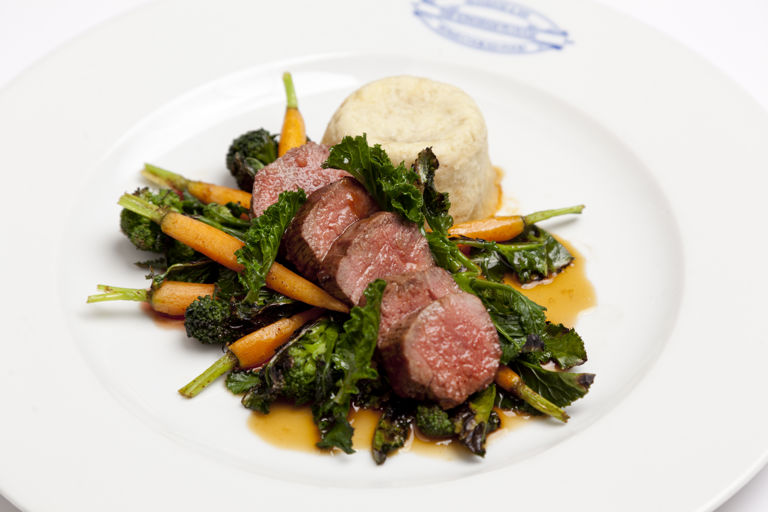 Lamb loin with steamed pudding, charred sprouting broccoli and baby carrots