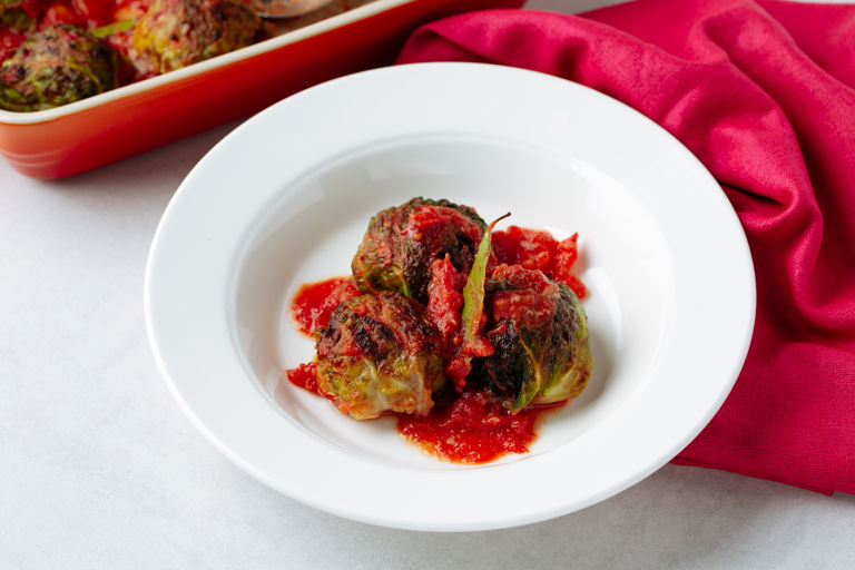 Stuffed beef and cabbage parcels, rice, onion and tomato sauce