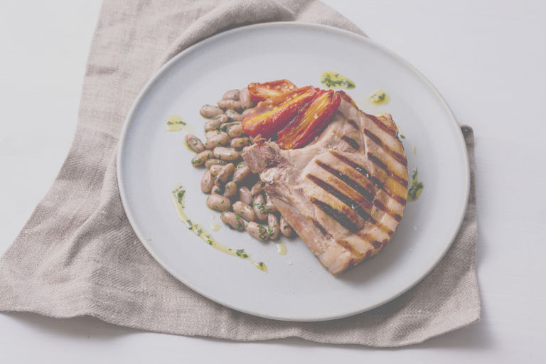 Barbecued sous vide pork chop with borlotti beans and candied tomato