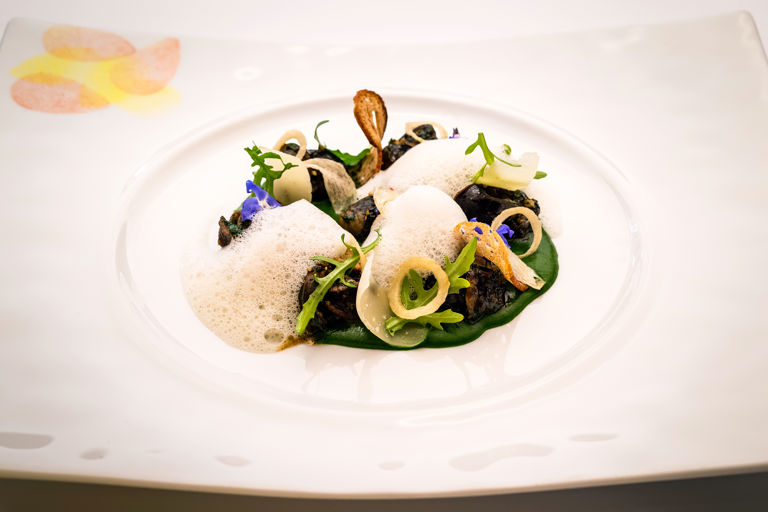 Snails served on a coulis of watercress with garlic crisps