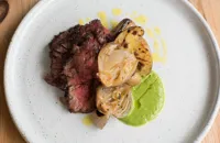 Barbecued bavette steak with green sauce, IPA-braised onions and barbecued potatoes