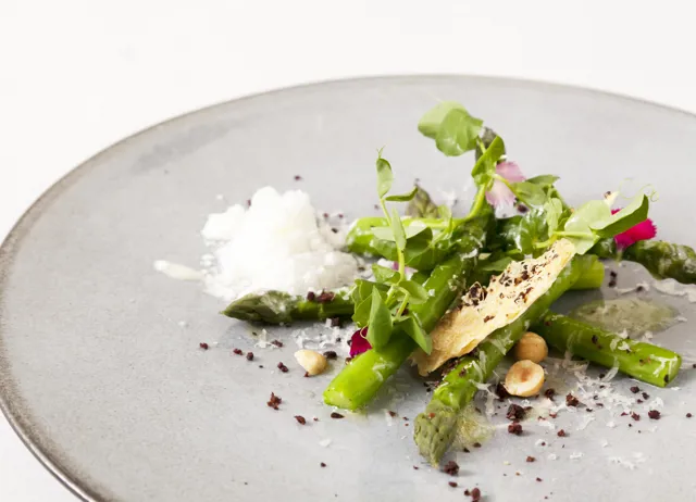 Asparagus with Parmesan snow, olive biscuit and hazelnuts