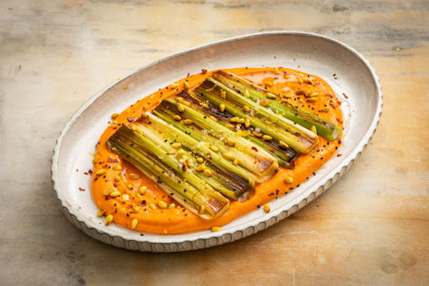 Pan-seared leeks with red pepper and chickpea spread, toasted pine nuts and lemon oil