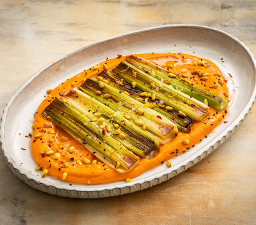 Pan-seared leeks with red pepper and chickpea spread, toasted pine nuts and lemon oil