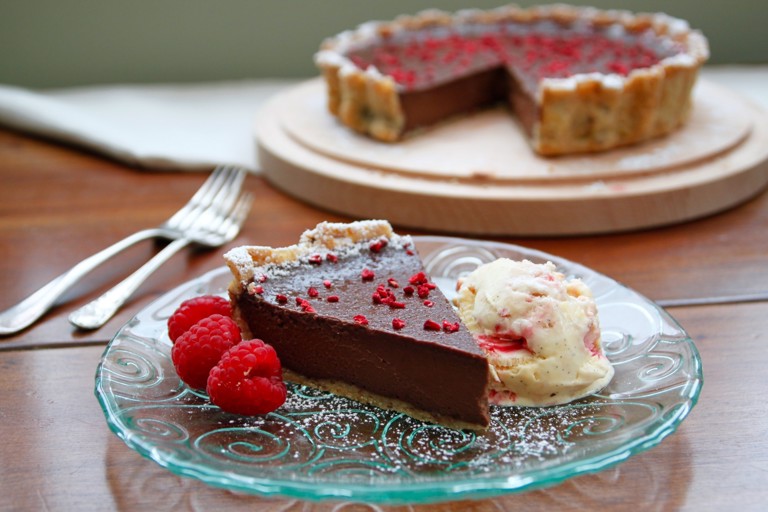 Dark chocolate and hazelnut tart with raspberry, pink peppercorn and crushed meringue ice cream 