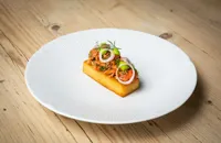 Smoked salmon tartare with potato Rosti, pickled cucumber, and dill emulsion