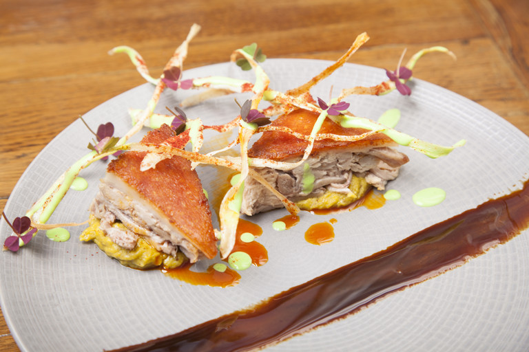 Confit suckling pig with corn purée and algarrobo syrup