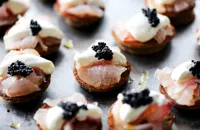 Citrus-cured sea bass on blinis with ossetra caviar and crème fraiche