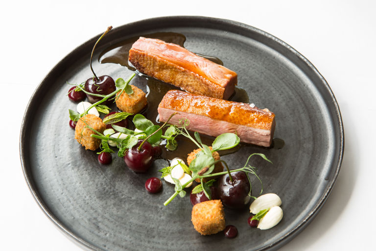 Roast duck breast and crispy leg croquettes with cherries and almonds