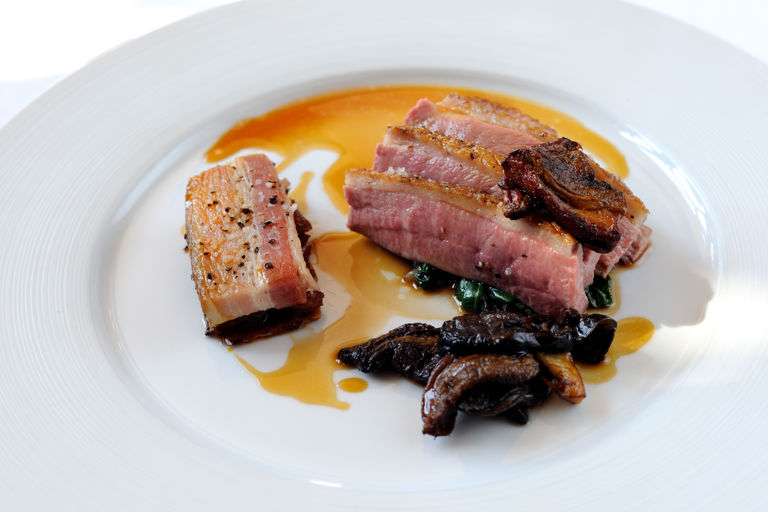 Honey-roasted breast of duck with smoked belly of pork, caramelised endive and ceps