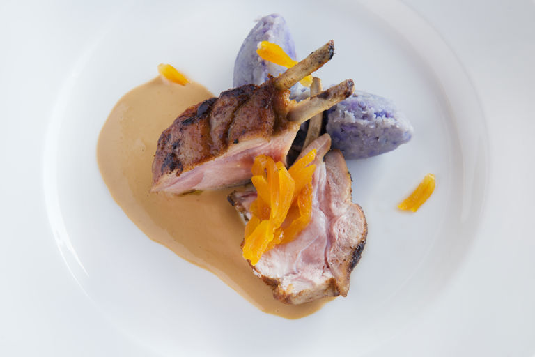 Rack of piglet with purple potatoes, dried apricots and garlic sauce