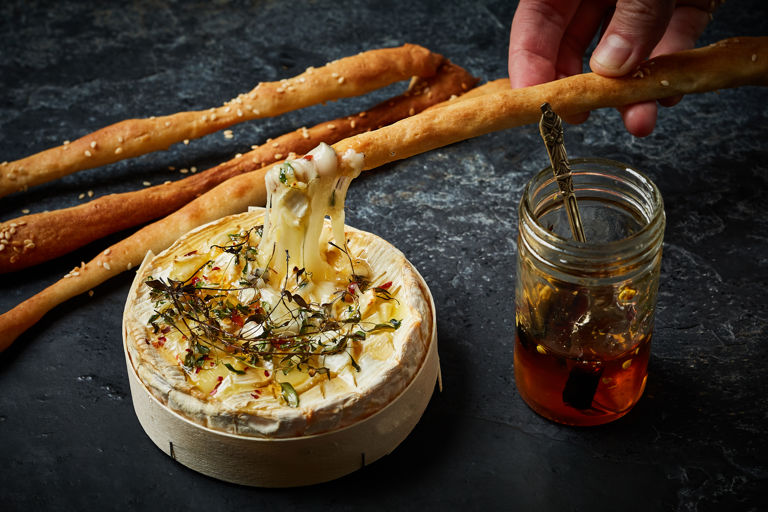 Baked camembert with garlic, thyme, chilli honey and sesame breadsticks