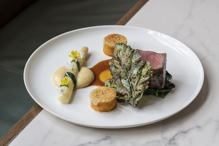 Hereford beef fillet with white asparagus, mustard greens, confit garlic and Parmesan 