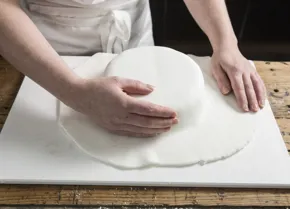 Run the palm of your hand around the cake, ensuring that there are no creases.
