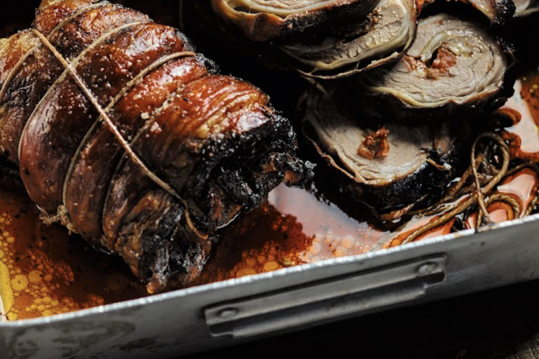 Rolled lamb breast with herbs, lemon and tomatoes