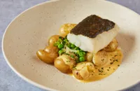 Baked cod with pea and lettuce fricassee, potatoes and mint Hollandaise