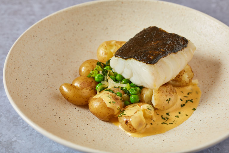 Baked cod with pea and lettuce fricassee, potatoes and mint Hollandaise