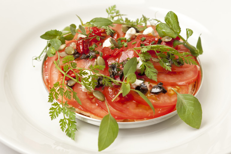 Baked tomato galette with goat's cheese, tapenade and pumpkin seeds