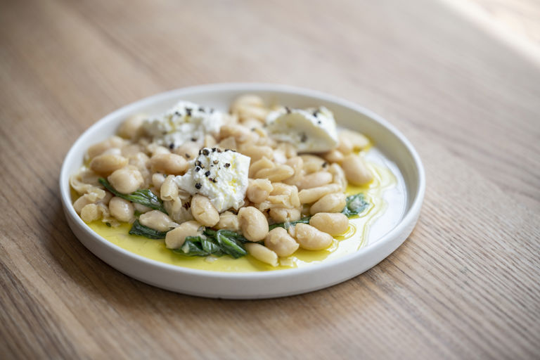 Braised butter beans with wild garlic and goat's curd