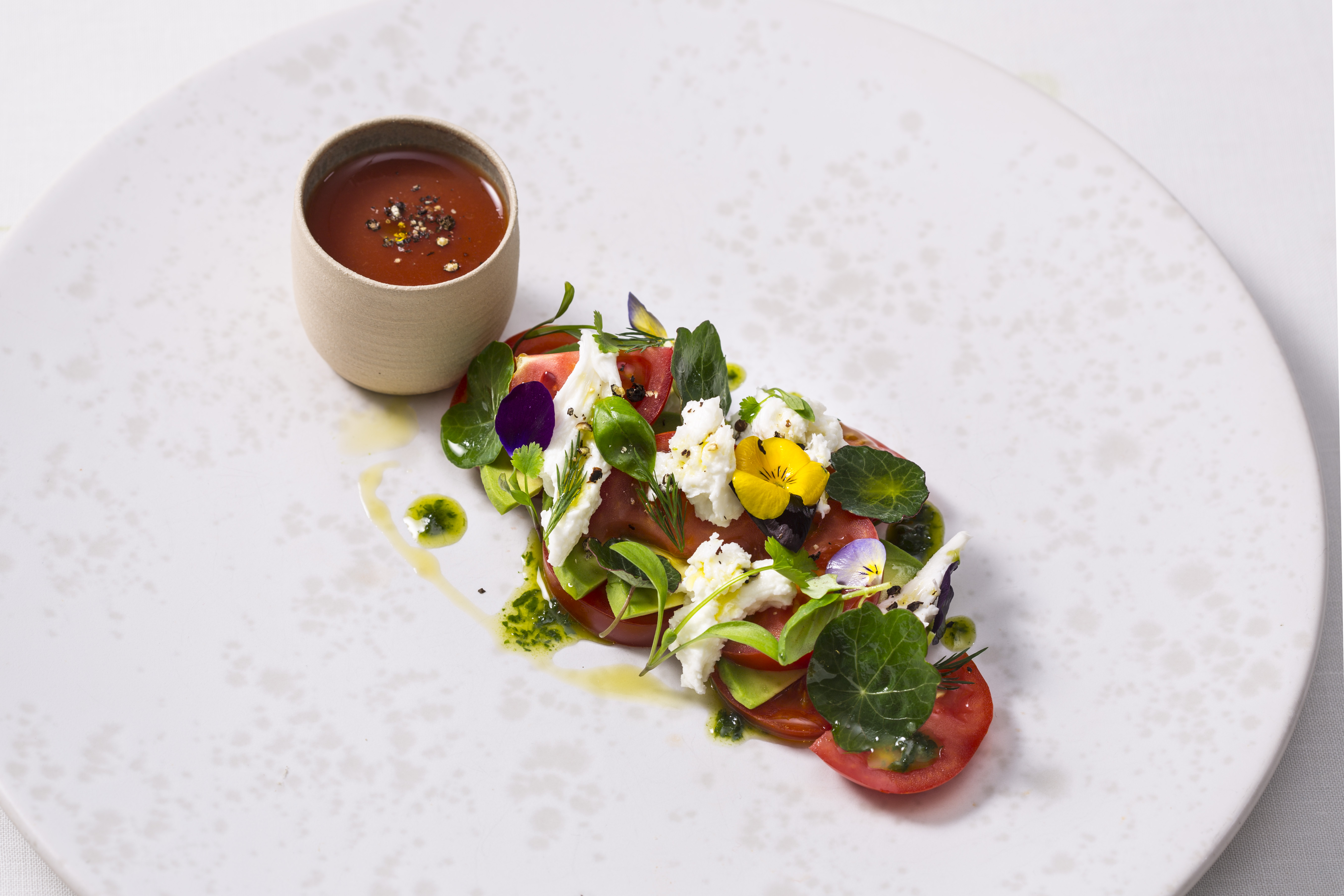 Image of A plate of nasturtium pesto with tomatoes and mozzarella