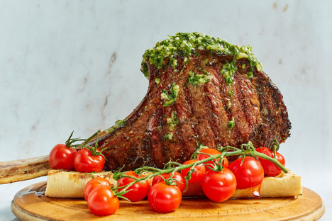 Barbecued tomahawk steak with miso, garlic bread, grilled tomatoes and tarragon salsa verde