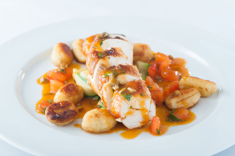 Breast of chicken with potato gnocchi, courgette ribbons and a tomato and olive sauce