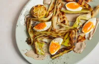 Charred leeks with leek ash crème fraîche, burnt citrus dressing and soft egg