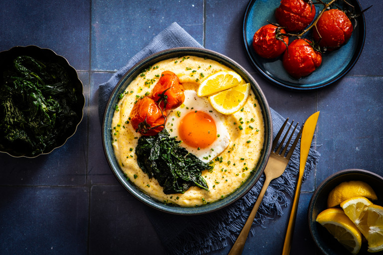 Cheesy eggs and grits with cavolo nero and roasted tomatoes
