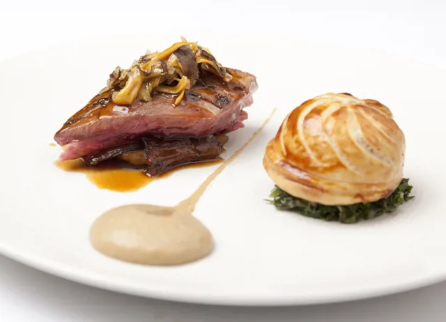 Roast wood pigeon with pithivier of leg, creamed curly kale and roast Jerusalem artichokes