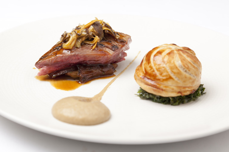 Roast wood pigeon with pithivier of leg, creamed curly kale and roast Jerusalem artichokes