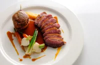 Pan-roast duck with sweet potato fondant, baby vegetables and cherry brandy sauce