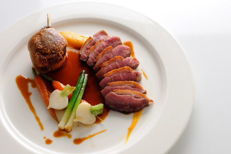 Pan-roast duck with sweet potato fondant, baby vegetables and cherry brandy sauce