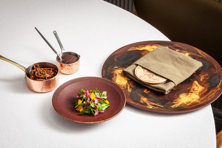 Churrasco (barbecued) lamb breast, black bean feijoada and cassava tacos