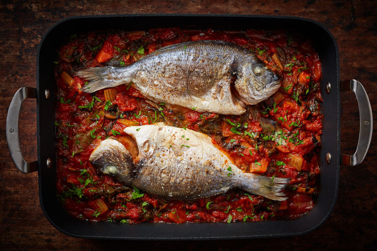 Whole baked bream with tomato and chard