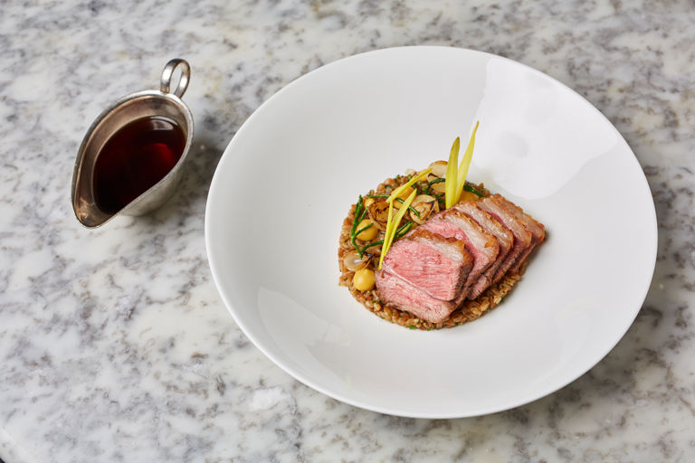Lamb rump with sweetcorn purée, braised baby onions, spelt and lamb consommé