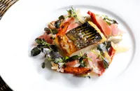 Fillet of sea bass with Parma ham, sauté artichokes and watercress