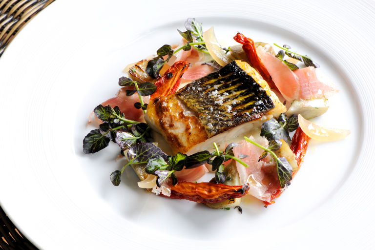 Fillet of sea bass with Parma ham, sauté artichokes and watercress