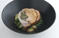 Herb-stuffed pork loin with spring greens and Jersey Royals